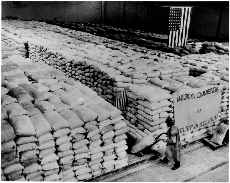 A warehouse in German occupied Belgium in WW1 with bags of flour for distribution under American supervision