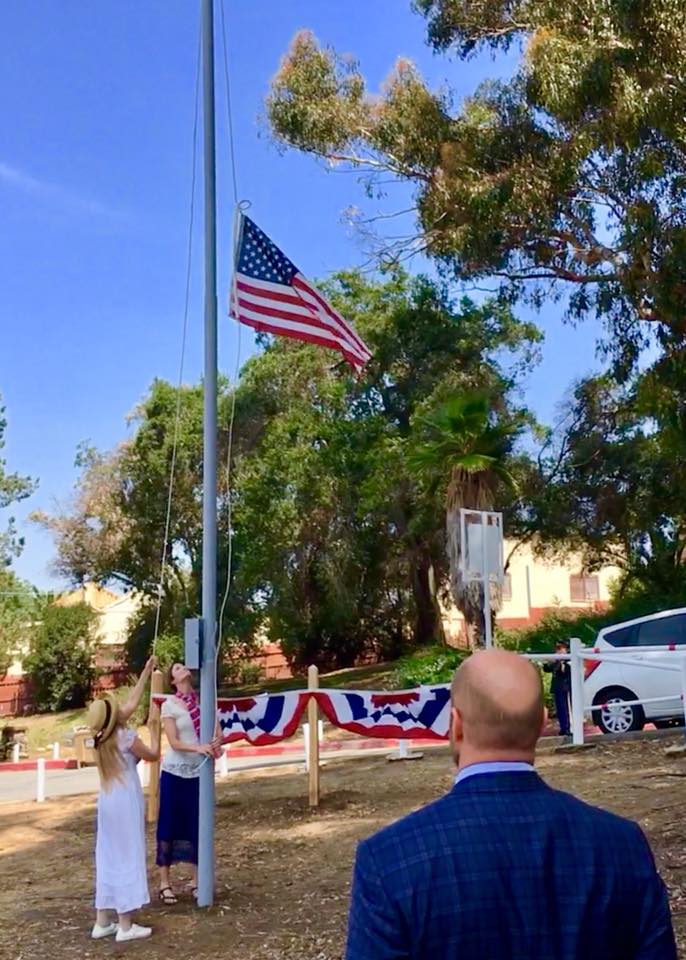 first flag being raised on the new pole by l a e d a r member kim jindra