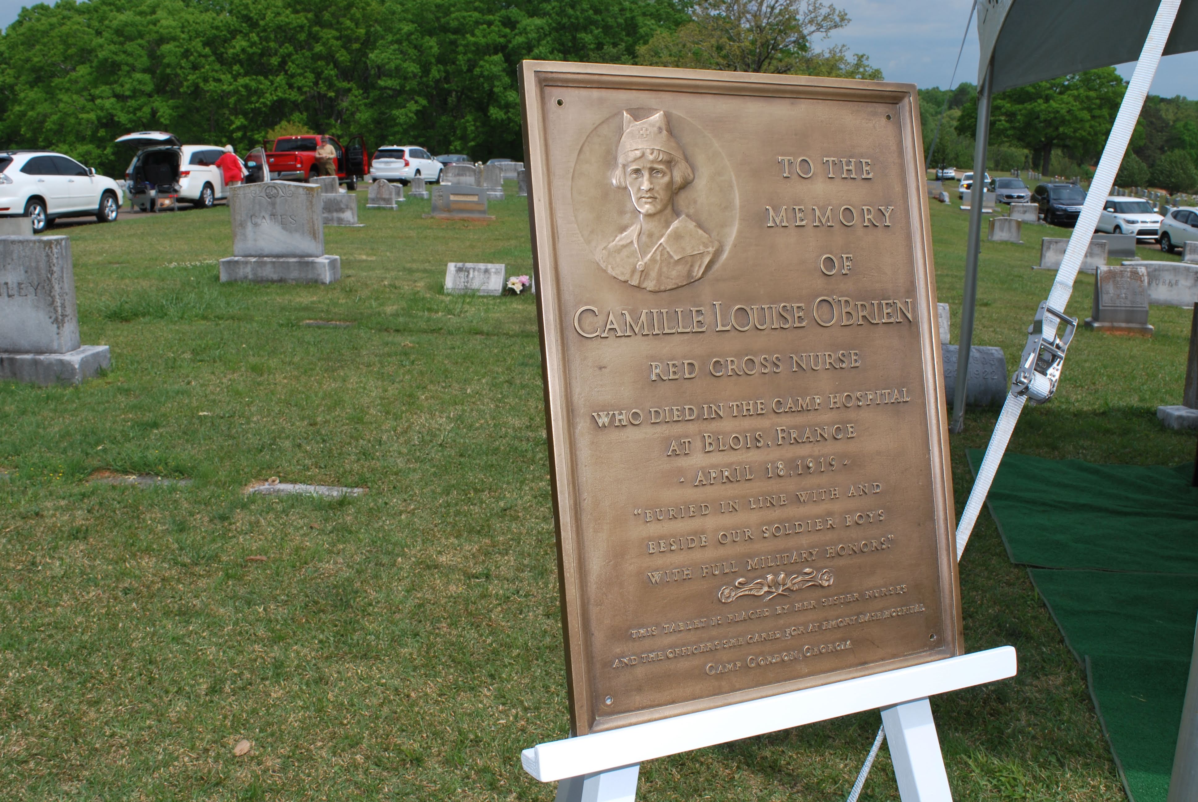 a bronze plaque dedicated to Camille Louise O'Brien on an easel