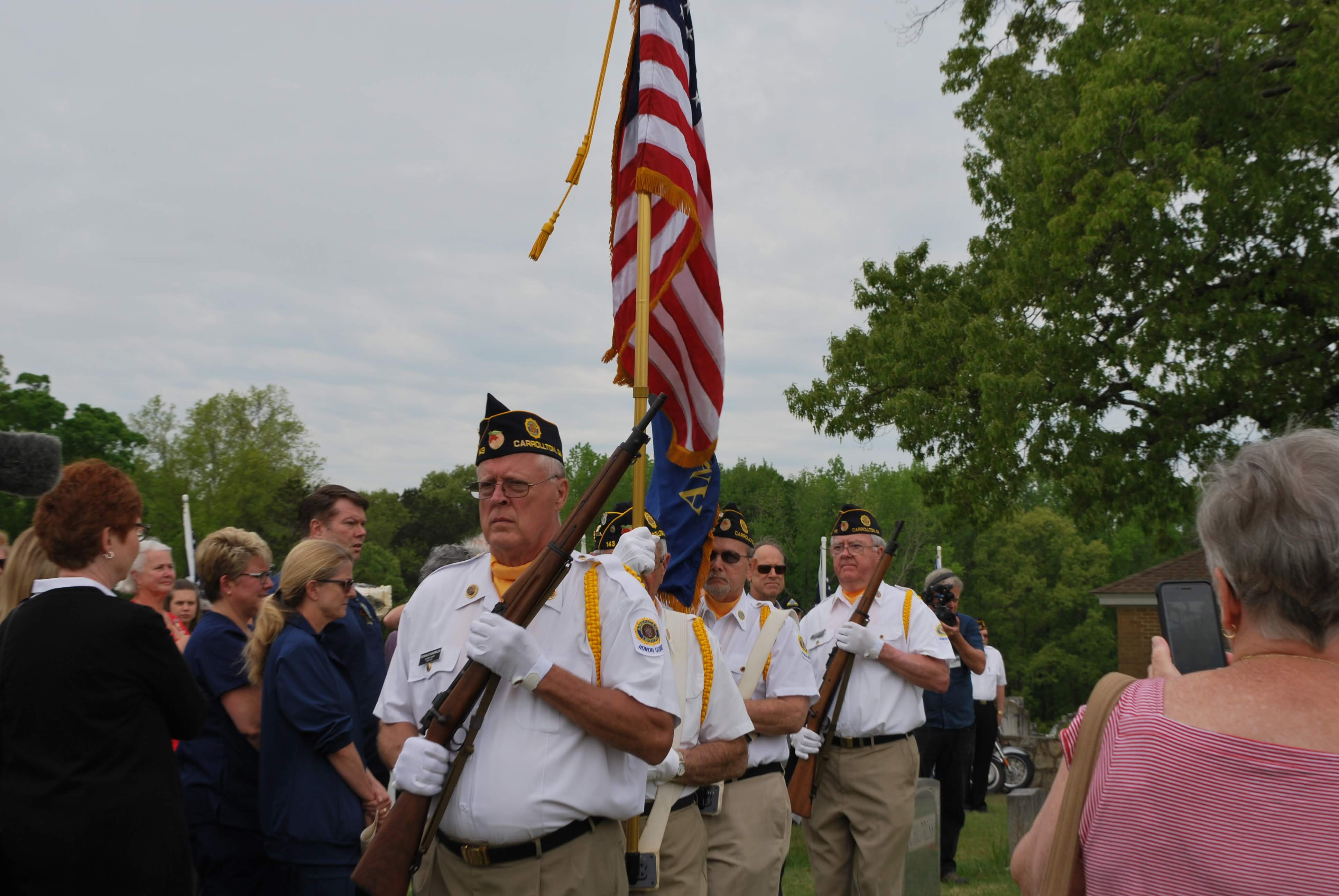 the color guard stand in a line with the US flag
