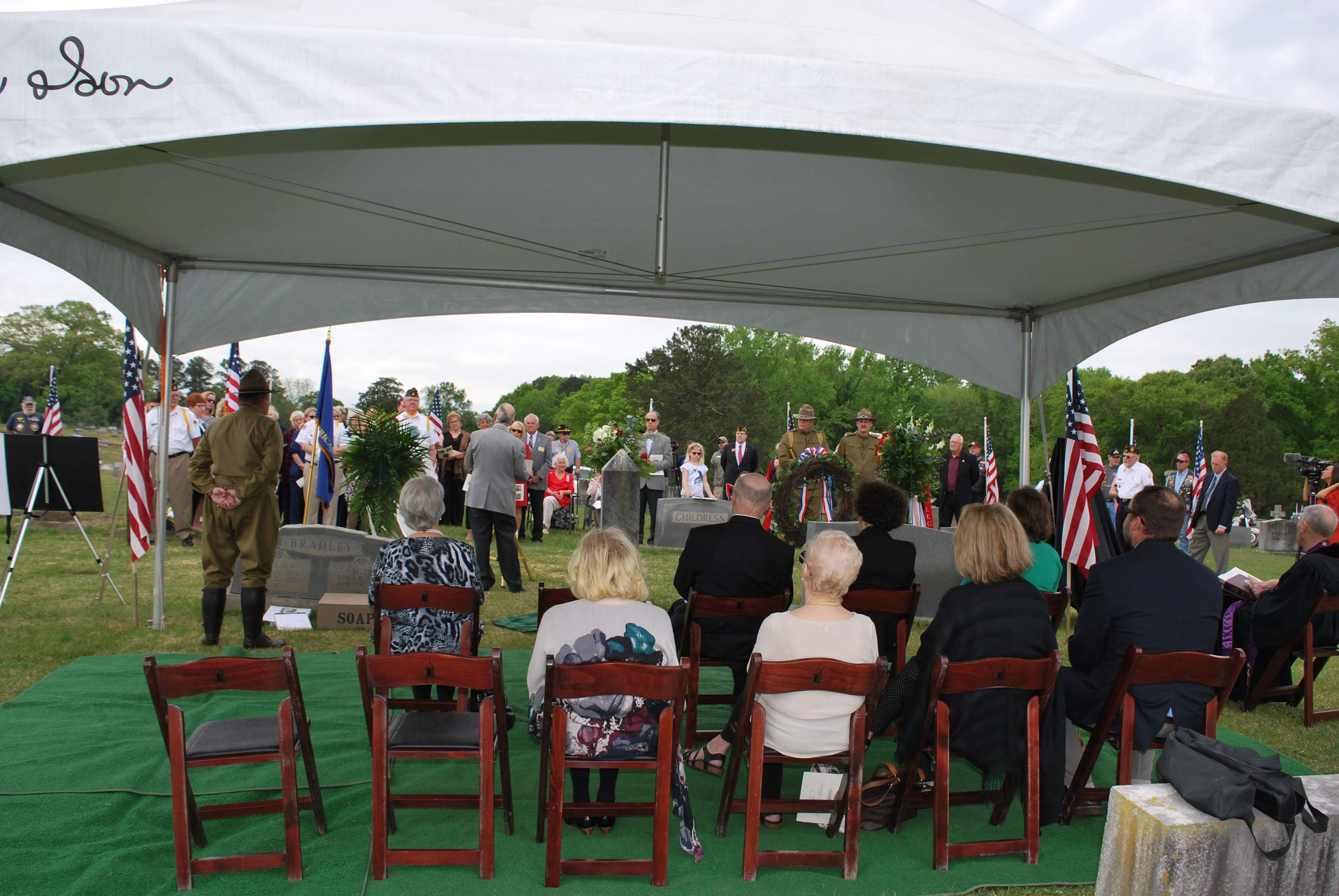 a view from behind people sitting under a green tent.