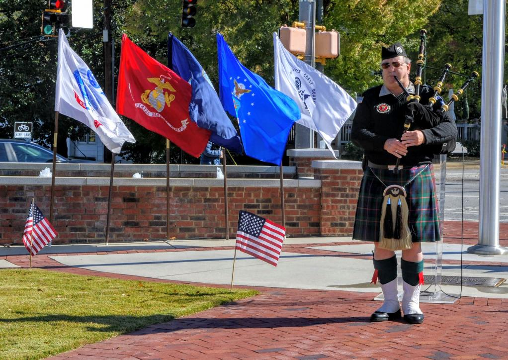 A man playing bagpipes and wearing a kilt.