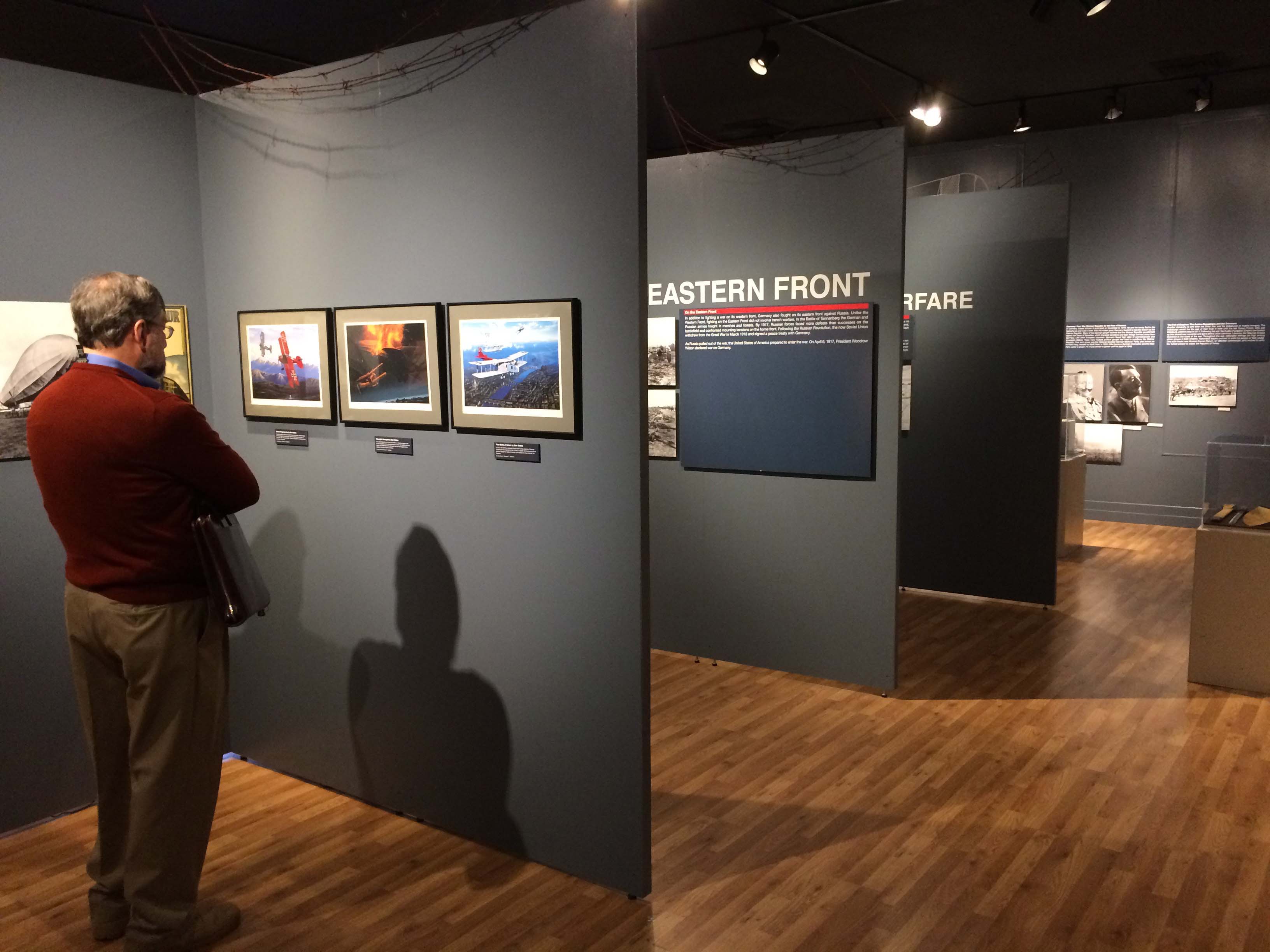 Image of Georgia Southern Museum. Man standing in front of wall looking at pictures.