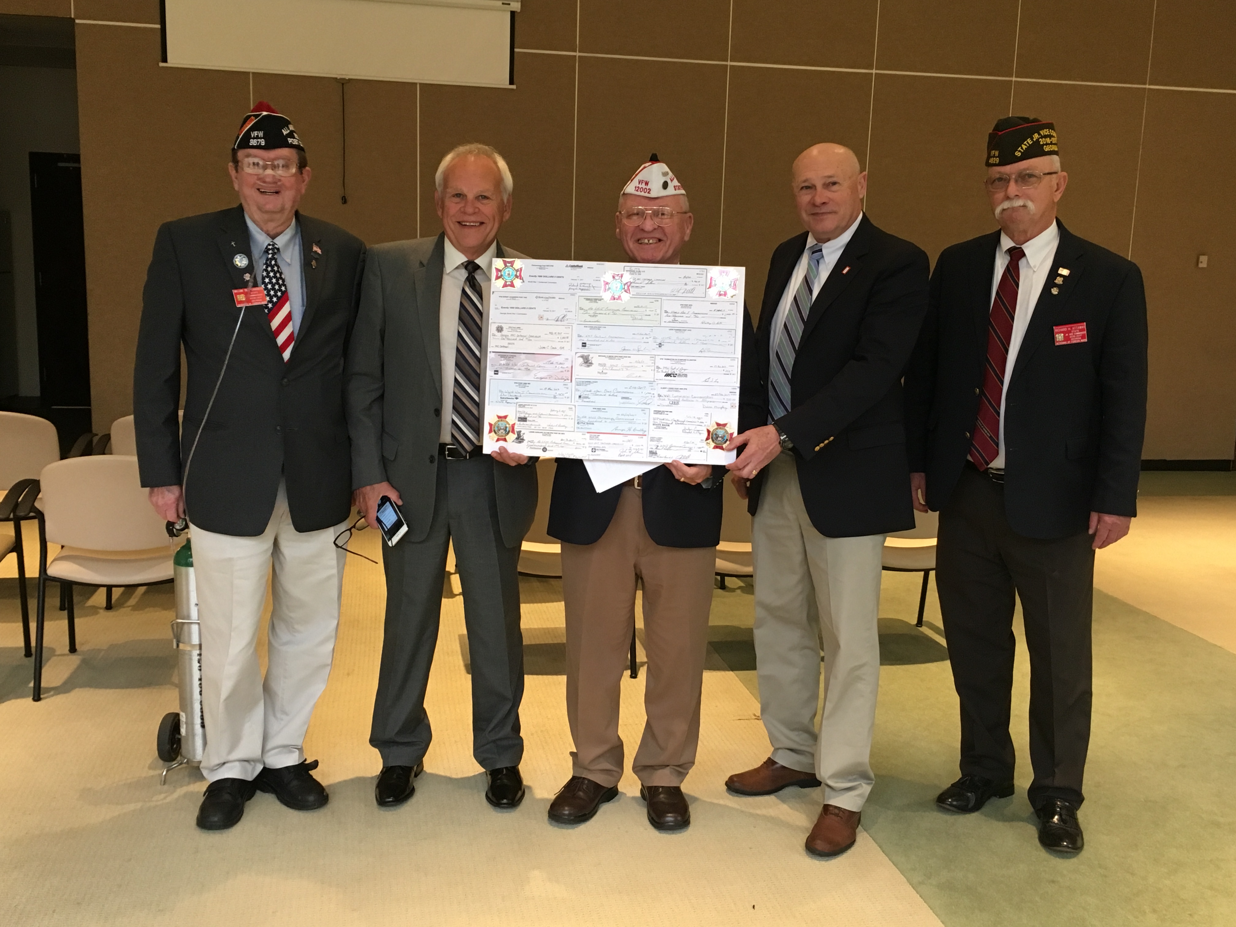 Left to right:  VFW Department of Georgia State Commander William Sandberg of VFW Post 3679, Fort Oglethorpe, Georgia; World War I Centennial Commission Member Rick Elder, VFW Post 7116 Sylvania; Al Lipphardt, VFW Department of Georgia Centennial Commission Advisory Member, member VFW Post 12002 North Fulton, Georgia; World War I Centennial Commission Chairman Dr. Billy Wells, University of North Georgia and VFW Department of Georgia Senior Vice Commander Richard Attaway, VFW Post 4629 LaGrange. The checks displayed are contributions from VFW Posts in Newnan, Athens, Fort Ogelthorpe, Snelville, Jesup, LaGrange, Cordele, Lake City, Lawrenceville, Douglas, Jonesboro, Thomaston, Fairburn, Sylvania, Buchanan, Northside, Dunwoody and North Fulton.