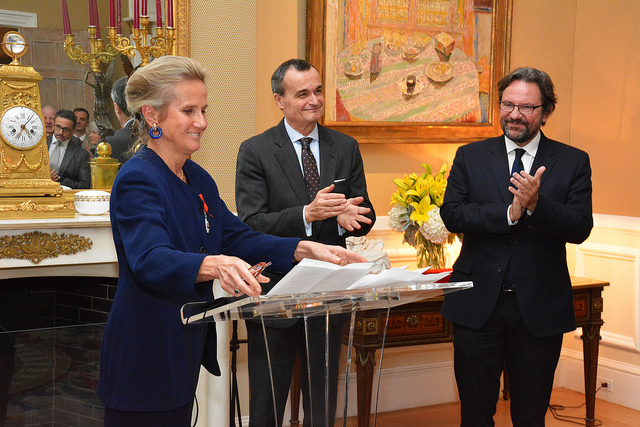 Commissioner Monique Seefried speaks at the podium next to Ambassador Gérard Araud