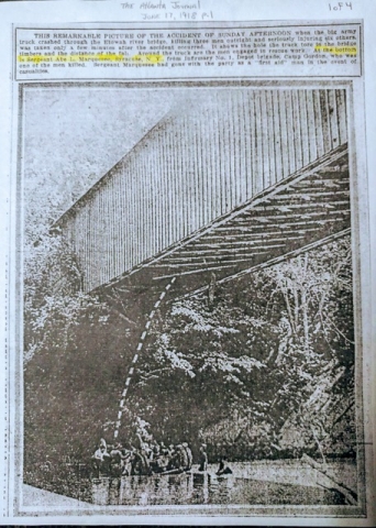 This photo was taken moments after the big army truck crashed through the bridge.  The bridge is a covered bridge and shows men down below in the water investigating the crashed truck.