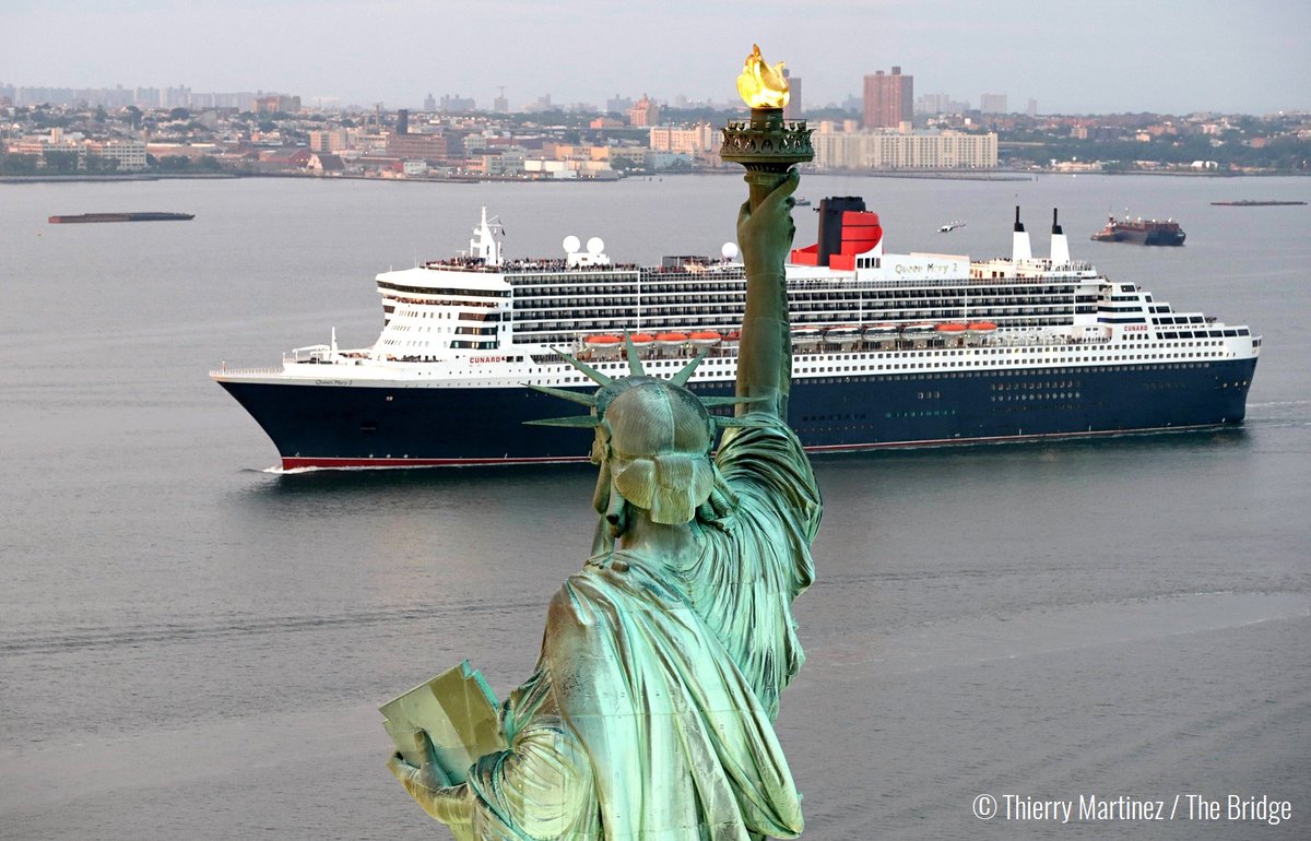 Queen Mary II passes the Statue of Liberty in New York Harbor at the end of "The Bridge" race across the Atlantic from France.